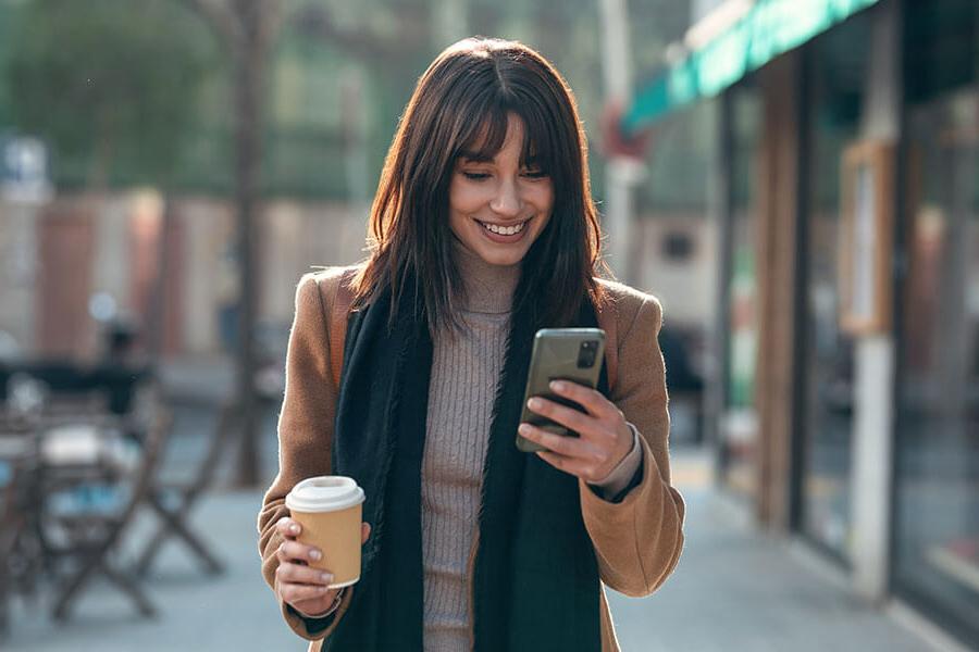 A woman manages her finances on the go with a credit union checking account.